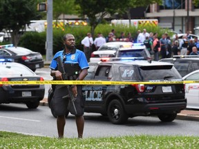 An officer takes a position outside of a building where a shooting took place at the Capital Gazette on Thursday June 28, 2018 in Annapolis, (Matt McClain/Washington Post)