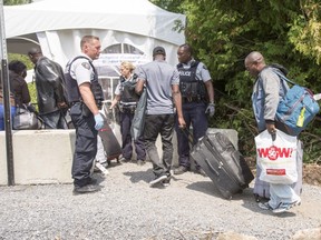 Asylum seekers cross the Canadian border at Champlain, N.Y., Friday, August 4, 2017. Ryan Remiorz/The Canadian Press
