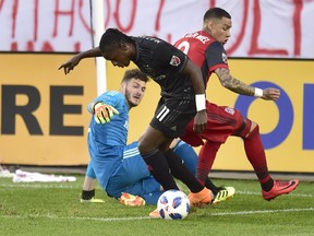 D.C. United forward Darren Mattocks (11) moves the ball pass Toronto FC goalkeeper Alex Bono (25) and Toronto FC defender Gregory van der Wiel (9) during MLS action in Toronto on Wednesday, June 13, 2018. (FRANK GUNN/THE CANADIAN PRESS)