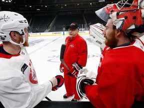 Washington Capitals head coach Barry Trotz, middle, chats with Travis Boyd, left, and goalie Philipp Grubauer, right, during an NHL hockey practice on June 6, 2018