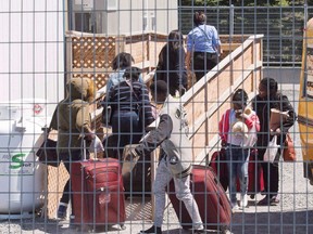 A group of asylum seekers arrive at the temporary housing facilities at the border crossing Wednesday May 9, 2018 in St. Bernard-de-Lacolle, Que. (Ryan Remiorz/The Canadian Press)