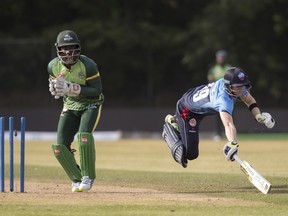 Toronto Nationals’ Steve Smith dives to score as Vancouver Knights wicket keeper Chadwick Walton looks on in the second inning of their Global T-20 Canada Cricket match in King City, Ont. last night.(The Canadian Press)