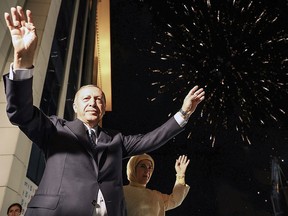 This handout picture released on June 25, 2018 shows Turkish President Tayyip Erdogan and his wife Emine Erdogan greeting supporters gathered above a balcony at the headquarters of the AK Party in Ankara, on June 24, 2018 as they celebrate Erdogan winning five more years in office with sweeping new powers after a decisive election victory.
