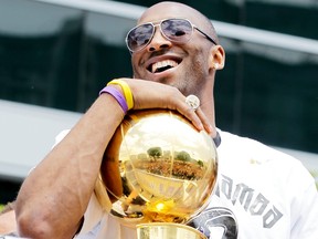 Los Angeles Lakers guard Kobe Bryant laughs with the championship trophy while riding in the victory parade for the the NBA basketball champion team on June 21, 2010 in Los Angeles, California. (Photo by Noel Vasquez/Getty Images)