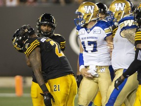 Hamilton Tiger-Cats linebacker Simoni Lawrence (21) tilts his head back and laughs after Winnipeg  quarterback Chris Streveler (17) said something to him following a yardage gain that was negated by a Blue Bombers penalty during second half CFL game action in Hamilton on Friday, June 29, 2018. Peter Power/The Canadian Press