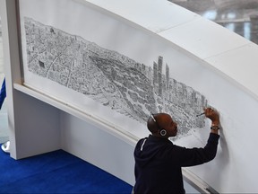 British artist Stephen Wiltshire draws freehand a panoramic view of Mexico City, in the Mexican capital, on October 26, 2016. (Yuri Cortez/Getty Images)