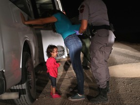 A two-year-old Honduran asylum seeker cries as her mother is searched and detained near the U.S.-Mexico border on June 12, 2018 in McAllen, Texas. The asylum seekers had rafted across the Rio Grande from Mexico and were detained by U.S. Border Patrol agents before being sent to a processing center for possible separation. Customs and Border Protection (CBP) is executing the Trump administration's zero tolerance policy towards undocumented immigrants. U.S. Attorney General Jeff Sessions also said that domestic and gang violence in immigrants' country of origin would no longer qualify them for political asylum status. (Photo by John Moore/Getty Images)