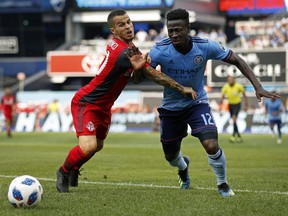 Toronto FC forward Sebastian Giovinco (left) and New York City FC midfielder Ebenezer Ofori battle for the ball during the second half of their game in New York on Sunday. (Adam Hunger/The Associated Press)