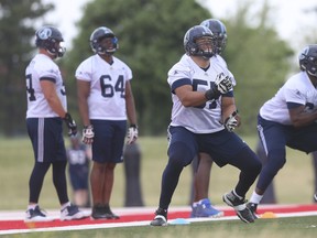 Argonauts’ offensive lineman 
Tyler Holmes (centre) works out during practice at York University. (Jack Boland/Toronto Sun)