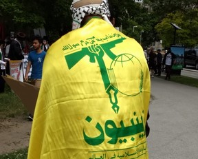 Demonstrator at Toronto’s al-Quds Day rally at Queen’s Park on Saturday wears the flag of the terror group Hezbollah. Joe Warmington/Toronto Sun