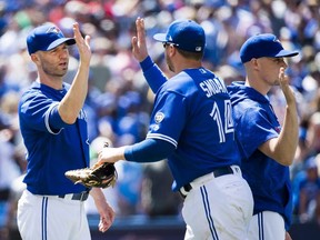 Blue Jays starting pitcher J.A. Happ, left, celebrates with teammate Justin Smoak (14) after defeating the Braves following Interleague action in Toronto on Wednesday, June 20, 2018.