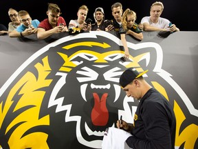 Hamilton Tiger-Cats quarterback Johnny Manziel signs autographs for fans after a CFL pre-season game against the Toronto Argonauts on June 1, 2018