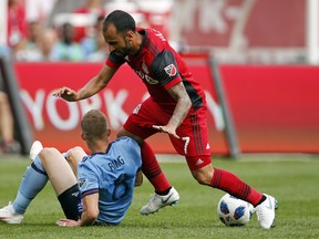 Toronto FC midfielder Jonathan Osorio (right) is tripped up by New York City FC midfielder Alexander Ring during the Red loss on Sunday.  Adam Hunger AP