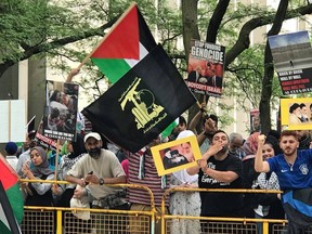 Demonstrator at Toronto's al-Quds Day rally at Queen's Park on Saturday wears the flag of the terror group Hezbollah. 
B'nai Brith Canada