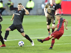 Toronto FC forward Sebastian Giovinco (10) take a shot towards the net as D.C. United defender Frederic Brillant (13) defends during MLS action in Toronto on Wednesday, June 13, 2018. (FRANK GUNN/THE CANADIAN PRESS)