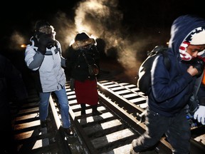 Migrants from Somalia cross into Canada illegally from the United States on Feb. 26, 2017, by walking down this train track into the town of Emerson, Man., where they will seek asylum at Canada Border Services Agency. THE CANADIAN PRESS/John Woods