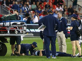 Coaching staff and players gather around Toronto Argonauts quarterback Ricky Ray (15) as he lays injured at BMO Field in Toronto on Saturday June 23, 2018. (THE CANADIAN PRESS/Cole Burston)