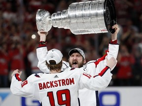 Washington Capitals left wing Alex Ovechkin, of Russia, hands the Stanley Cup to center Nicklas Backstrom, of Sweden, after the Capitals defeated the Golden Knights 4-3 in Game 5 of the NHL hockey Stanley Cup Finals Thursday, June 7, 2018, in Las Vegas.