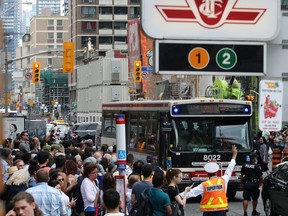 TTC officials scramble to load transit riders onto shuttle buses at Yonge and Bloor. Dave Abel/Toronto Sun