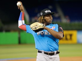 In this July 9, 2017, file photo, World Team designated hitter Vladimir Guerrero Jr., of the Toronto Blue Jays, warms up before the All-Star Futures game in Miami