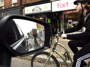 Cyclists ride on the designated Bloor Street bike lanes in Toronto. (Nathan Denette/The Canadian Press)