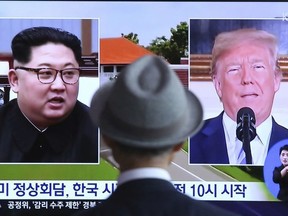 A man watches a TV screen showing file footage of U.S. President Donald Trump, right, and North Korean leader Kim Jong Un during a news program at the Seoul Railway Station in Seoul, South Korea, Monday, June 11, 2018.