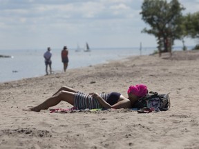 A woman suntans at Centre Island Beach in Toronto. (Stan Behal/Toronto Sun files)