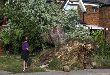 An uprooted tree following a storm that passed by a home by Humewood Park, near Vaughan Rd. and St. Clair Ave. W.,  in Toronto, Ont. on Wednesday June 13, 2018. Ernest Doroszuk/Toronto Sun/Postmedia