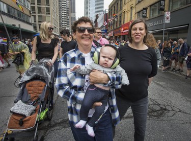 Patricia Homer looks on as Alison Aston holds their 4 month old baby, Rosemary, in the Dyke March 2018 along Yonge St. in downtown Toronto, Ont.  on Saturday June 23, 2018. Ernest Doroszuk/Toronto Sun/Postmedia