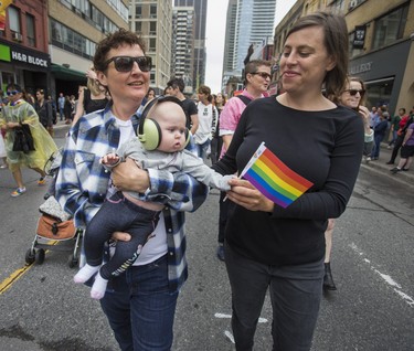 Patricia Homer looks on as Alison Aston holds their 4 month old baby, Rosemary, in the Dyke March 2018 along Yonge St. in downtown Toronto, Ont.  on Saturday June 23, 2018. Ernest Doroszuk/Toronto Sun/Postmedia
