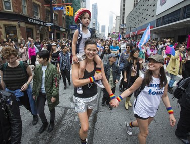 Rachel Trozzolo holds carries her child, Dylan, age 4, in the Dyke March 2018 along Yonge St. in downtown Toronto, Ont.  on Saturday June 23, 2018. Ernest Doroszuk/Toronto Sun/Postmedia