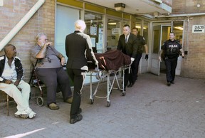 Police remove the body of a man that was shot at an apartment building on Sherbourne St. north of Dundas on Monday June 25, 2018. Veronica Henri/Toronto Sun