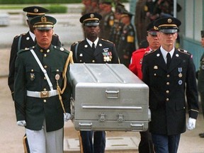 In this May 14, 1999, file photo, U.N. honour guards carry a coffin containing the remains of American soldiers after it was returned from North Korea at the border village of Panmunjom, South Korea.