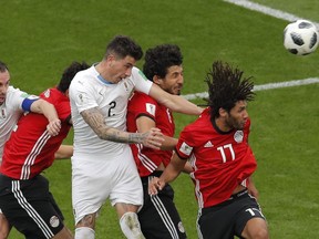 Uruguay's Jose Gimenez, center, heads the ball to score the opening goal during the group A match between Egypt and Uruguay at the 2018 soccer World Cup in the Yekaterinburg Arena in Yekaterinburg, Russia, Friday, June 15, 2018. (AP Photo/Vadim Ghirda)