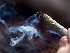 A young man smokes a marijuana joint.