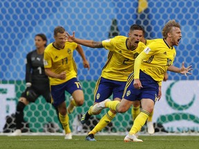 Sweden's Emil Forsberg, (right) celebrates with teammates after scoring against Switzerland on Tuesday. (AP PHOTO)