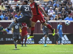 Minnesota United forward Christian Ramirez and Toronto FC defender Nick Hagglund jump for a header during Wednesday's game. (AP PHOTO)