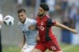 Sporting Kansas City forward Diego Rubio works against Toronto FC midfielder Jonathan Osorio during Saturday night's game. (AP PHOTO)