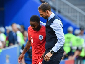 England coach Gareth Southgate greets forward Raheem Sterling during their match against Sweden on Saturday. (GETTY IMAGES)