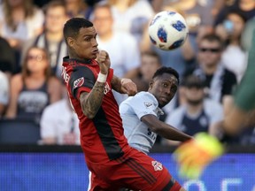 Sporting Kansas City forward Gerso Fernandes shoots the ball past Toronto FC defender Gregory van der Wiel during Saturday's game. (AP PHOTO)