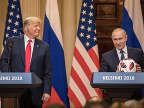 Russian President Vladimir Putin hands U.S. President Donald Trump, left, a World Cup football during a joint press conference after their summit on July 16, 2018 in Helsinki, Finland. (Chris McGrath/Getty Images)