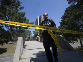 A Toronto Police officer at the scene of a shooting in the Driftwood Ave.-Jane St. area. (STAN BEHAL, Toronto Sun)