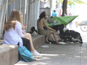 A man lives under a makeshift shelter is just metres away from the Victoria St. safe-injection site. (JACK BOLAND, Toronto Sun)