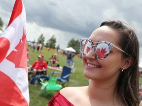 The reflection of the Canadian Flag is seen in the sunglasses of Tiana Beaudry moments before she sings O Canada during the Canada Day celebrations at the Sunova Centre in the RM of West St. Paul, Man., north of Winnipeg, Man., on Sunday, July 1, 2018.