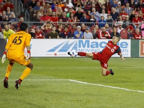 Toronto FC's Sebastian Giovinco passes the ball off to Jonathan Osorio, not pictured, to score against Chicago Fire's Richard Sanchez during Saturday's game. (THE CANADIAN PRESS)