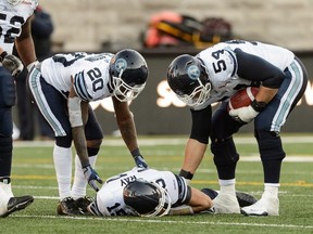 Veteran Argos lineman Chris Van Zeyl (54) checks on teammate Ricky Ray after one of the quarterback’s previous serious injuries a few years back. Van Zeyl feels Ray will bounce back from the neck injury suffered in the home opener.