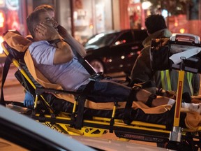 Paramedics attend to a victim of Sunday night's mass shooting on Danforth Ave. (Victor Biro photo)