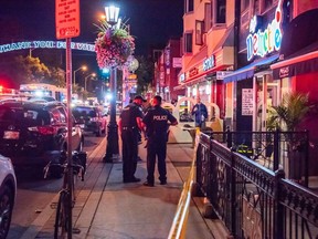 Paramedics attend to a victim of Sunday night's mass shooting on Danforth Ave. (Victor Biro photo)