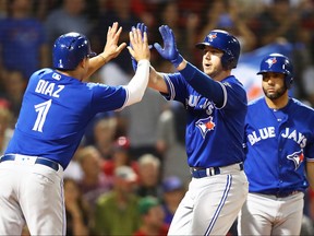 Toronto Blue Jays Justin Smoak high fives Aledmys Diaz hitting a two-run home run in the ninth inning of a game against the Boston Red Sox at Fenway Park on July 13, 2018 in Boston.  (Adam Glanzman/Getty Images)