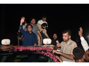 Chairman of the Pakistan Peoples Party (PPP) Bilawal Bhutto Zardari (L) waves from a car to supporters during an election campaign rally in Lahore on July 19, 2018, ahead of Pakistan's election.